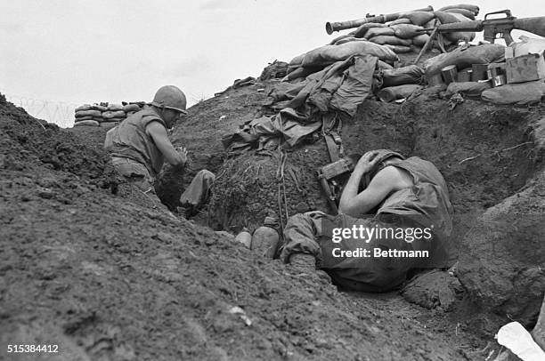 Crouching in muddy trenches, U.S. Leathernecks keep down as incoming Communist mortar zero in on their position during running four-day attack...