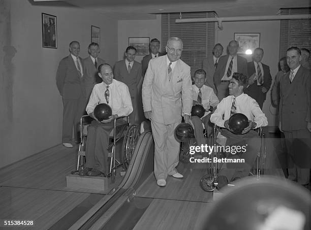 President Truman today presented championship awards to three paralyzed bowling champions from veterans administration hospitals at a White House...