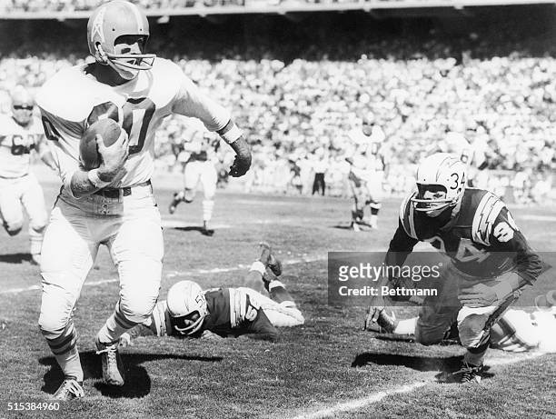 Billy Cannon, Houston halfback, eludes San Diego Charger defenders Emil Karas and Bob Zeman to roll up 13 yards for an Oiler first down. Play set up...