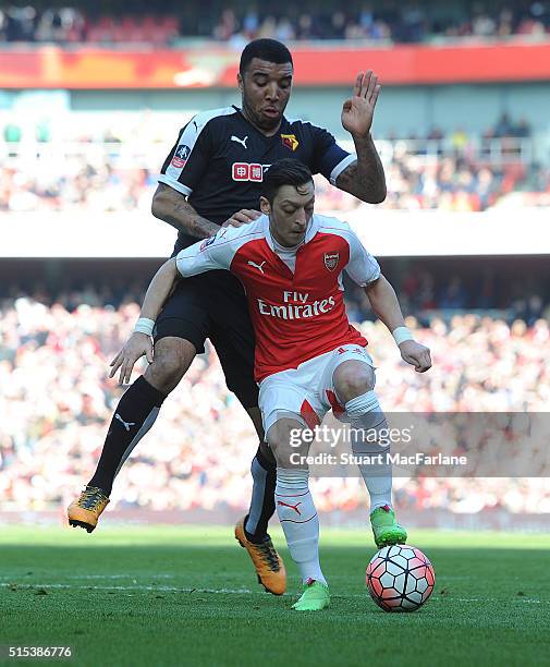 Mesut Ozil of Arsenal holds off Troy Deeney of Watford during the Emirates FA Cup Sixth Round match between Arsenal and Watford at Emirates Stadium...