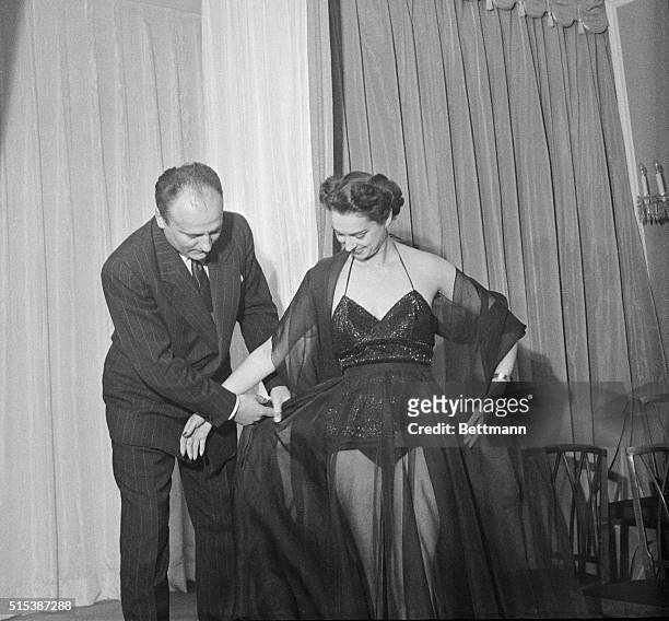 Parisian designer Pierre Balmain is here with a model wearing his "Midnight Bathing Suit" with skirt.