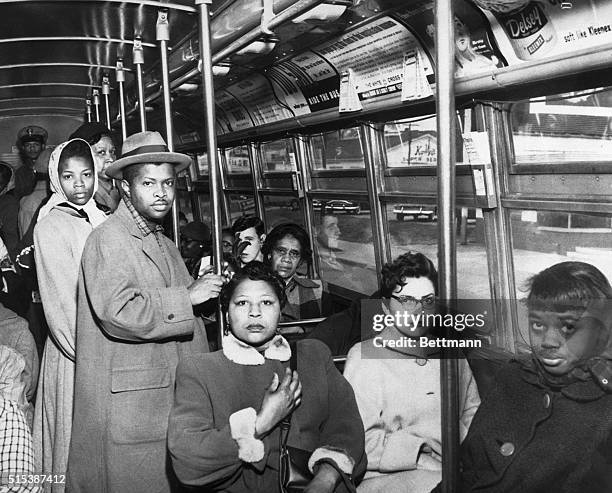 Black and white passengers sit side by side on a Norfolk, Virginia, bus as racial segregation of intrastate transportation ended per U.S. Supreme...