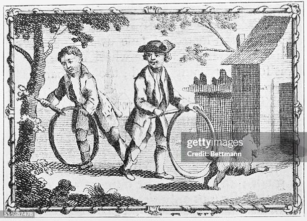 Two colonial boys, with a dog, playing hoops.