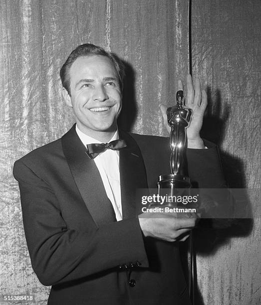 Actor Marlon Brando is all smiles as he holds his Oscar which was awarded to him for the best actor of 1954. Brando, who won the Oscar for his...