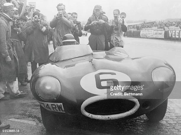 The young British driver, Mike Hawthorn, brings in the winning Jaguar after passing the post in the 1955 Le Mans Race.