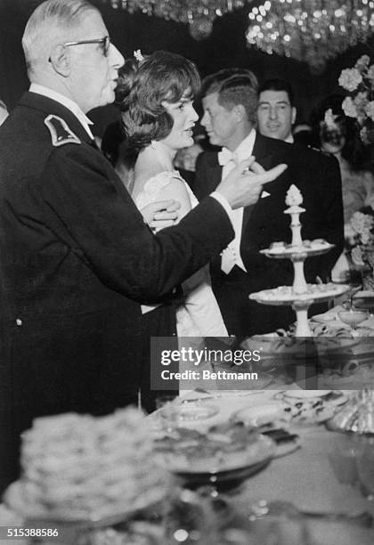 Playing host at state banquet for the visiting U.S. Chief Executive, French President Charles de Gaulle gestures at refreshment table. Formal affair...