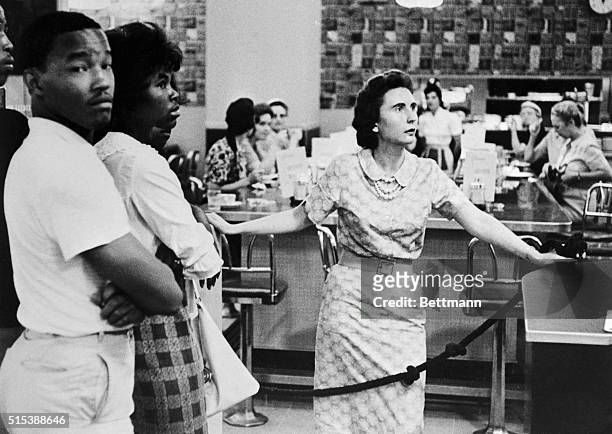 Caucasian woman hurriedly bars the way as Negroes were about to enter the lunch counter of this downtown department store in Memphis to protest the...