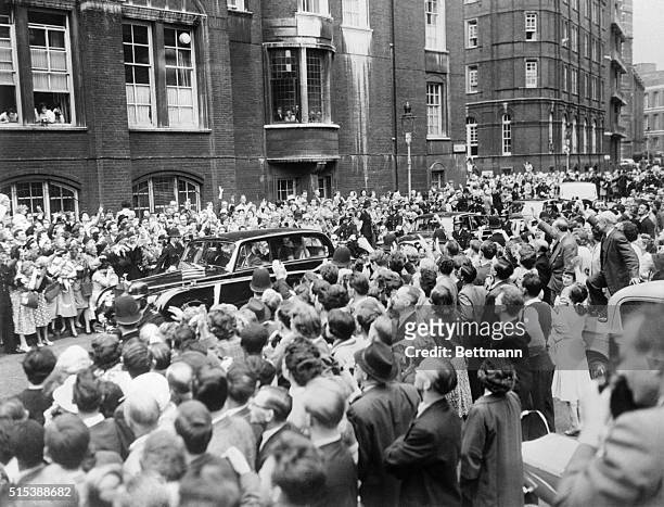 Kennedy's Enroute To Christening. London: Crowds cheer automobile carrying President John Kennedy and his wife Jacqueline to Westminister Cathedral...