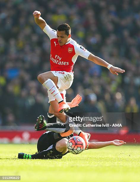 Alexis Sanchez of Arsenal jumps over Ben Watson of Watford during the Emirates FA Cup match between Arsenal and Watford at the Emirates Stadium on...