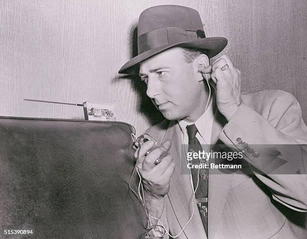 Wiretap Devices Story. One of the tiniest tapping gadgets is demonstrated by Mort Davis, of the N.Y. Daily Mirror, equipped with hearing aid and...