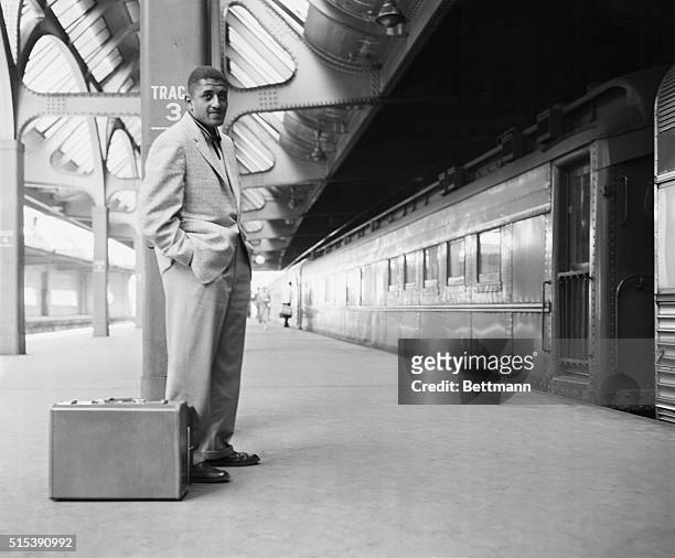 Don Newcombe of the Brooklyn Dodgers awaits a train at the Newark Penn Station. Newcombe is going to rejoin his teammates in Philadelphia following...