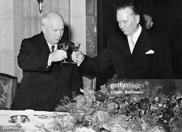 Nikita Khrushchev, head of the Soviet Communist Party is shown clinking glasses with Yugoslav President Marshall Tito at the reception given by Tito...