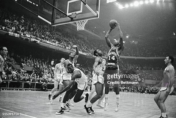 The "Big O", Oscar Robertson of the Cincinnati Royals, keeps three Boston Celtics players busy as he scores during first quarter action at Boston...