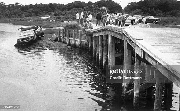 Edgartown, MA- Curious spectators look on from pier at the car driven by Massachusetts Senator Edward Kennedy which plunged off a bridge on Martha's...