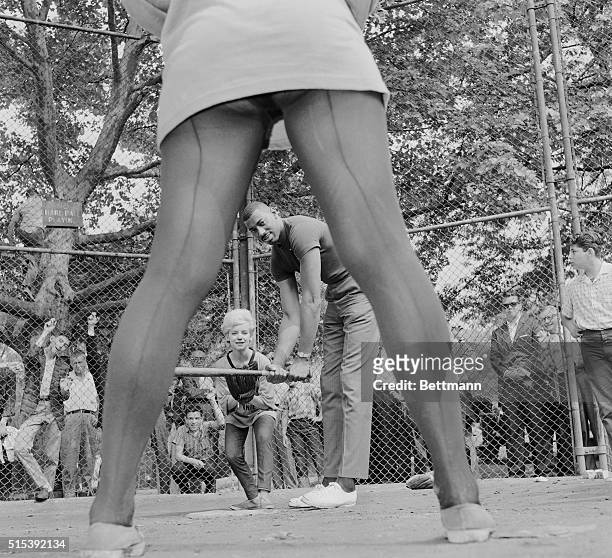 New York: Pretty As A Pitcher. A figure familiar to basketball fans, Wilt "The Stilt" Chamberlain, stoops to conquer as he prepares to display his...