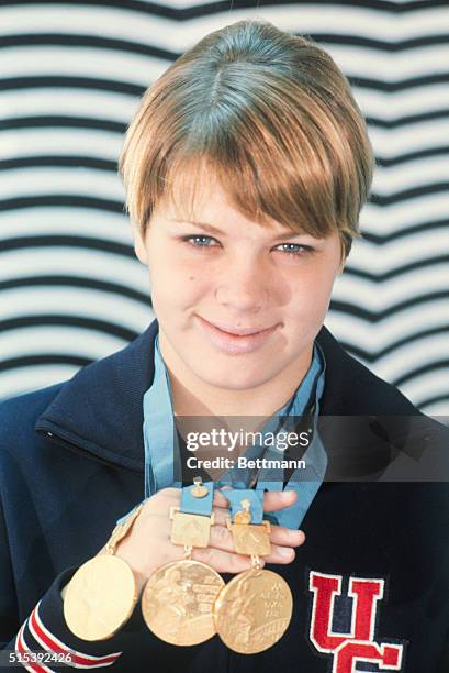 Debbie Meyer, the 16-year-old Miss America of Olympic swimming, displays 3 Gold Medals she's won for the 200 meter, 400 meter and 800 meter freestyle.