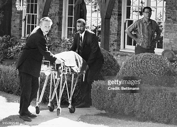 Coroner's office personnel wheel the body of film actress Sharon Tate from her home in Bel Air, California, August 9th after she and four others were...