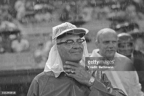 Wearing rain gear against a heavy thunderstorm, Vince Lombardi, new head coach of the Washington Redskins watches his team play the Chicago Bears in...