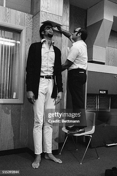 Milwaukee Bucks trainer, Arnie Garber, needed a chair as he measured all & foot 1 and 5/8 inches of Lew Alcindor, the Bucks rookie during physical...