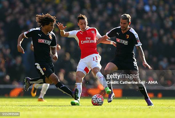 Mesut Ozil of Arsenal is tackled by Nathan Ake and Valon Behrami of Watford during the Emirates FA Cup match between Arsenal and Watford at the...