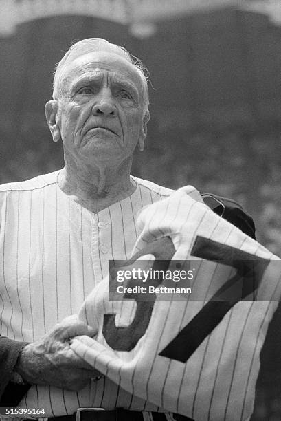 Still celebrating his 80th birthday, Casey Stengel is given his old New York Yankee uniform by Whitey Ford, , and Yogi Berra as his famous number 37...