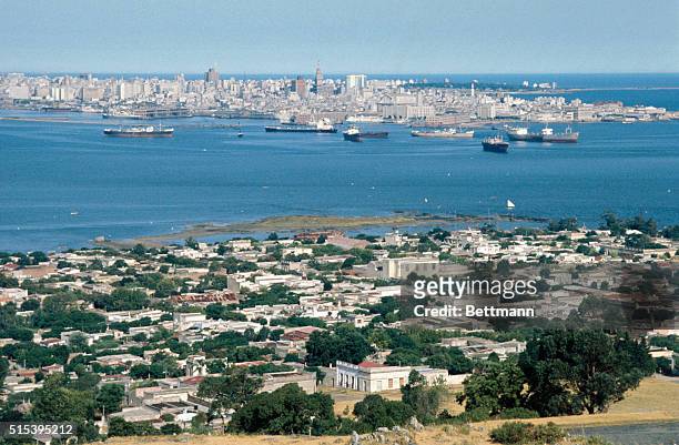 Montevideo, Uruguay- Montevideo Harbor and the downtown skyline as seen from El Cerro across the bay. An old colonial fortress tops the hill and an...