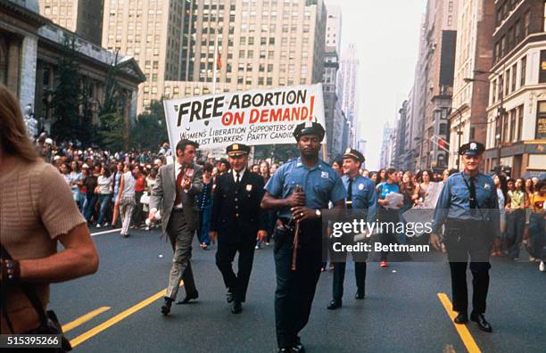 New York, New York: Women's liberation groups march down Fifth Avenue and will end with rally at Bryant Park. A prominently displayed sign reads,...