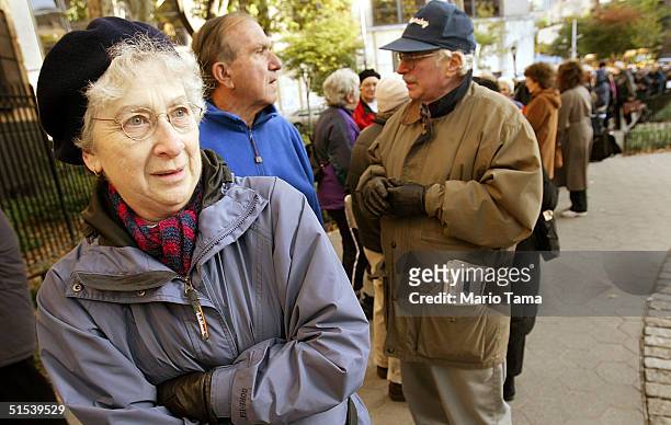 Ruby Vogelfanger, 69-years-old, stands with soon-to-be flu vaccine recipients as they wait in line outside the District Health Center October 22,...