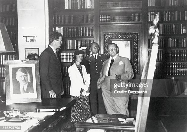 American pilot Charles Lindbergh is meeting with German citizens surrounded by Nazi photos and mementos.