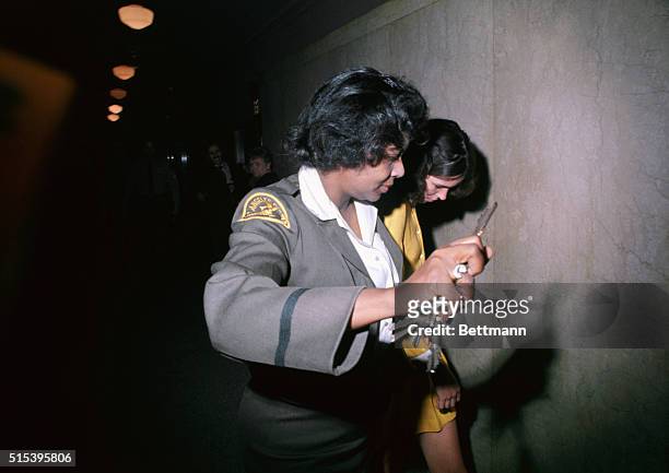 Los Angeles, California: Leslie Louis Van Houghten, , is taken by policewomen to a jail cell in the Hall of Justice, after she and two other girls...
