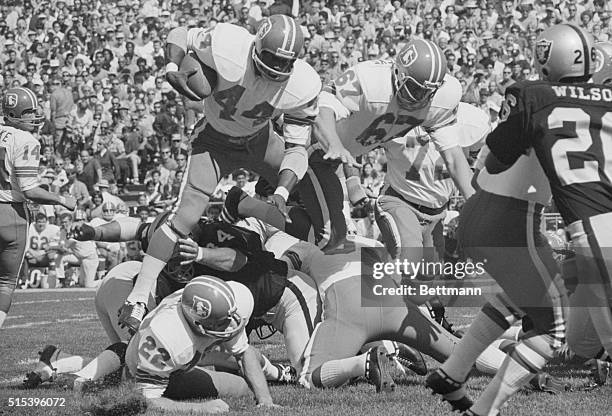 Denver Broncos' Floyd Little and George Goeddekel climb over a pile of players including Fran Lynch in first quarter of the game against the Oakland...