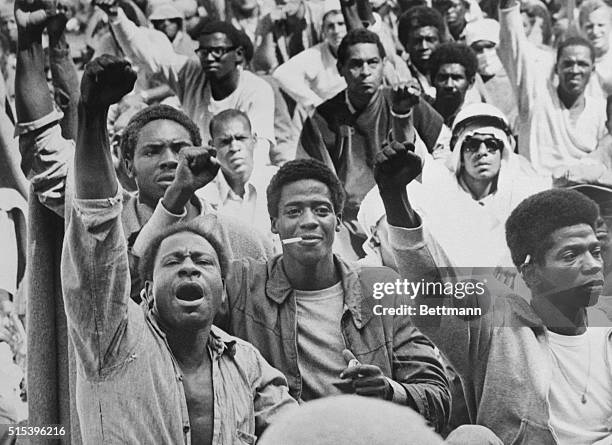 Rebellious inmates at the Attica Correctional Facility give the black power salute while Commissioner R.G. Oswald negotiates with leaders of the...