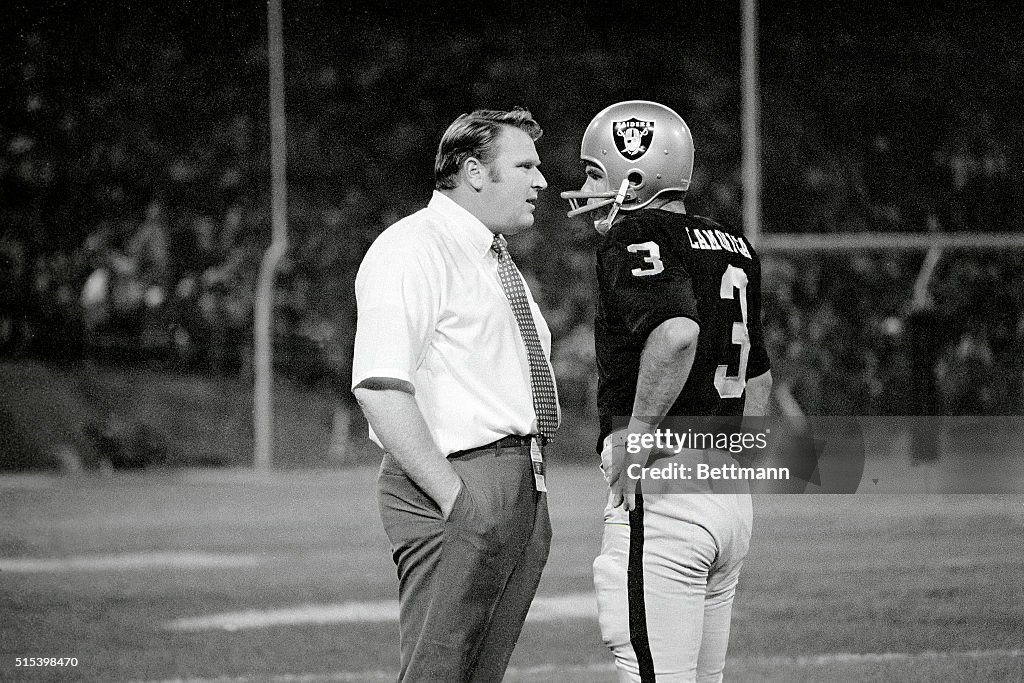 Coach Conversing with Football Player