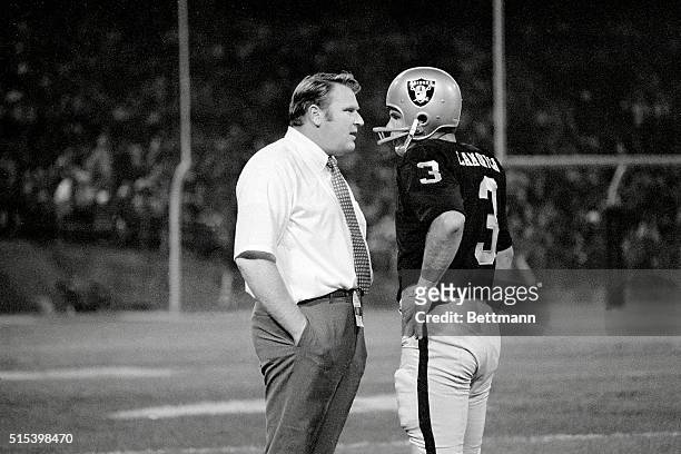 Oakland Raiders coach John Madden, and his quarterback Daryle Lamonica go over battle plans during the 3rd period against the Washington Redskins...