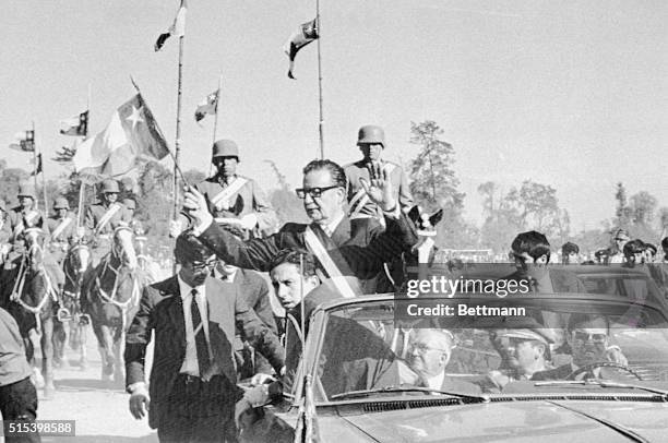 Chile's President, Marxist Salvador Allende, waves to the crowd en route to a military parade. The bodyguards surrounding Allende were chosen from...