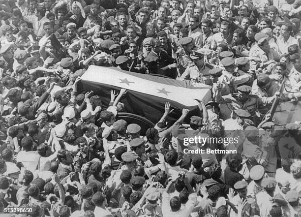 Mourners reach out to touch the flag-draped coffin of UAR President Gamal Abdel Nasser during funeral procession here October 1st. Nasser was buried...