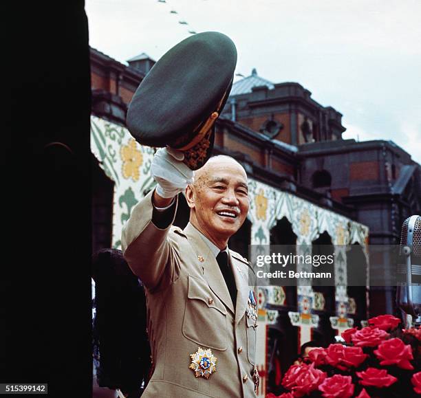 Taipei, Taiwan: President Chiang Kai-Shek smiling and waving hat during mass rally celebrating the 59th anniversary of Nationalist China's founding.