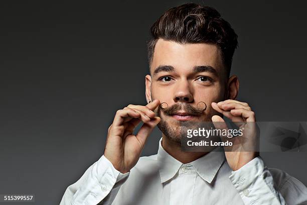 retrato de hombre joven tocando su moustaches - bigote manillar fotografías e imágenes de stock