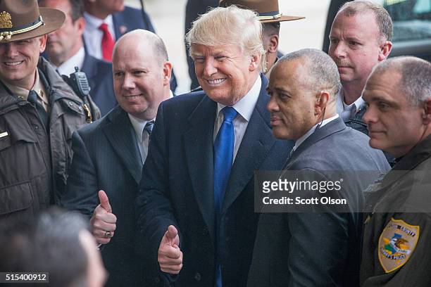 Republican presidential candidate Donald Trump poses with law enforcement officers following a rally at the Central Illinois Regional Airport on...