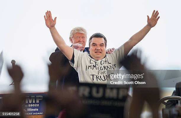 Republican presidential candidate Donald Trump pulls Alex Stypik from a crowd of supporters to show off his shirt during a rally at the Central...