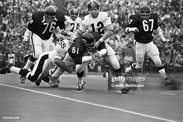 Chicago Bears' linebacker Dick Butkus is tackled by Pittsburgh Steelers' Jon Kolb and quarterback Terry Bradshaw after intercepting a Bradshaw pass...