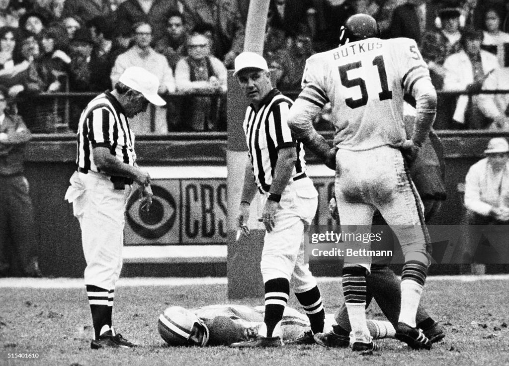 Dick Butkus Watches as Chuck Hughes Lies on Field
