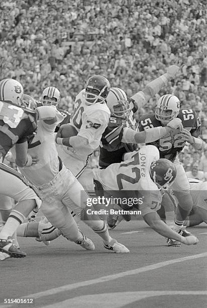 University of Oklahoma RB Gregg Pruitt shoulders his way past University of Auburn DT Larry Taylor for a short gain in the 1st quarter of the sugar...