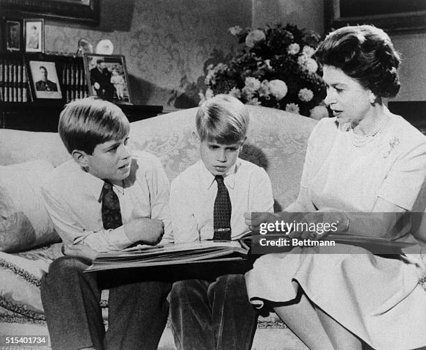 The Queen at home. London: Queen Elizabeth II leafs through family album with two of her sons, Andrew and Prince Edward, in photo made recently at...