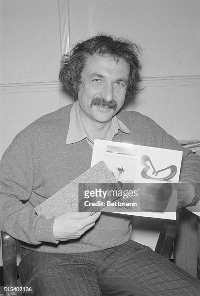 New York City: Los Angeles architect Frank O. Gehry holds a sample of the corrugated paperboard material from which furniture in picture is made....