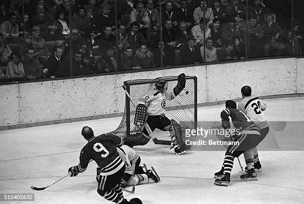 Bobby Hull of the Chicago Blackhawks sends the puck flying past Boston Bruins goalie Gerry Cheevers and scores his 600th NHL goal. Bruins defenseman...