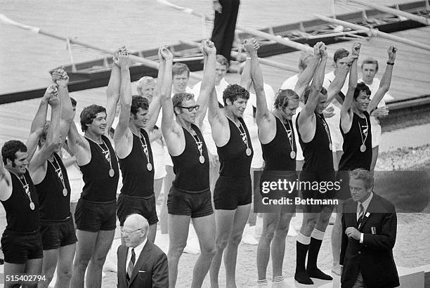 Munich: Members of the first place eights rowing team of New Zealand raise their hands in victory after being presented Olympic gold medals 9/2 by...