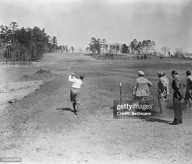 Bobby Jones tries out his "perfect course" in the making. Here's a rear view of the King of Golfers, Bobby Jones, testing shots on his new National...