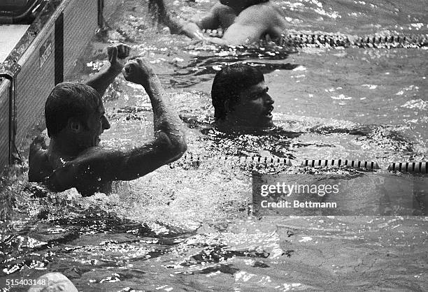 Vladimir Bure raises his arms after he finished third to Mark Spitz of Carmichael, CA, in the 100-meter Olympic freestyle swimming competition here...