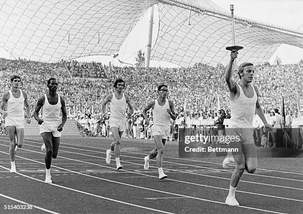 Gunter Zahn , 18-year-old West German junior athlete and a policeman, carries Olympic Flame as he arrives for opening ceremonies for the XX Olympiad...
